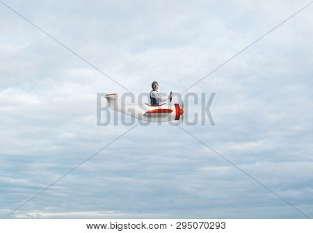 Happy Pilot Driving Small Propeller Plane On Background Of Blue Sky With Clouds. Traveling Around Th