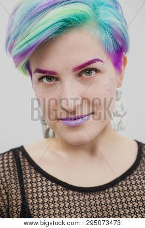 A Young Woman With Short Hair, A Pixie Bob Haircut, Different Colored Hair, Blue, Green, Violet.