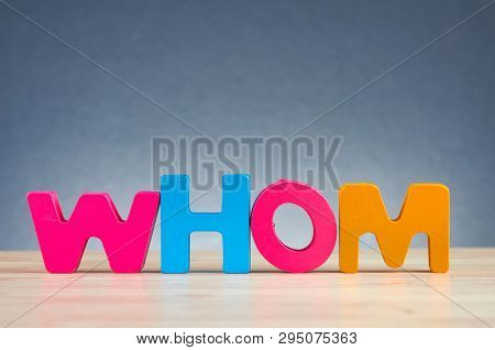 The Word Whom Spelled Using Wooden Alphabet On Desk Over  Gently Lit Dark Background For Information