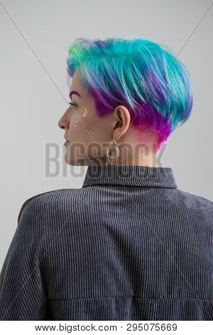 A Young Woman With Short Hair, A Pixie Bob Haircut, Different Colored Hair, Blue, Green, Violet.