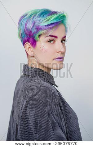 A Young Woman With Short Hair, A Pixie Bob Haircut, Different Colored Hair, Blue, Green, Violet.