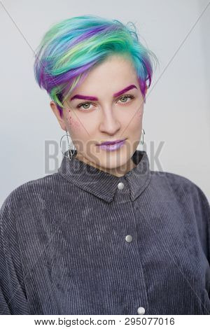 A Young Woman With Short Hair, A Pixie Bob Haircut, Different Colored Hair, Blue, Green, Violet.