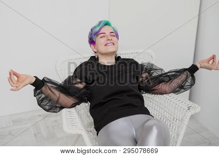 A Young Woman With Short Hair, A Pixie Bob Haircut, Different Colored Hair, Blue, Green, Violet.