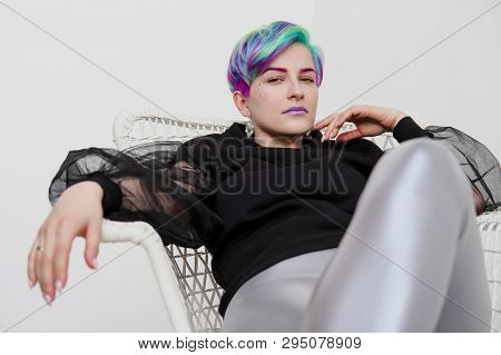 A Young Woman With Short Hair, A Pixie Bob Haircut, Different Colored Hair, Blue, Green, Violet.