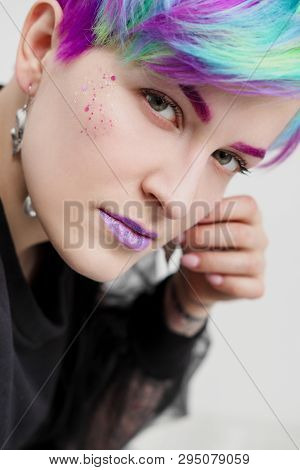A Young Woman With Short Hair, A Pixie Bob Haircut, Different Colored Hair, Blue, Green, Violet.