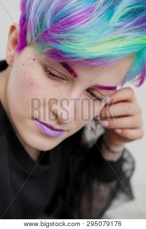 A Young Woman With Short Hair, A Pixie Bob Haircut, Different Colored Hair, Blue, Green, Violet.