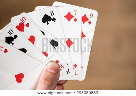 Playing Cards: Poker Cards In The Hand Of A Man