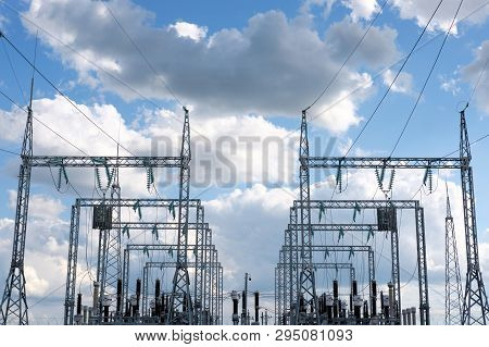 Electricial High Voltage Power Stantion, Blue Cloudy Sky On Background