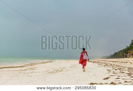 One Unrecognizable Man Goes Into The Distance On The Ocean Ohland And Carries A Bag On His Shoulderw