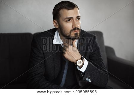 Modern Businessman. Confident Young Man In A Trendy Suit Looking Away While Sitting Indoors On The S