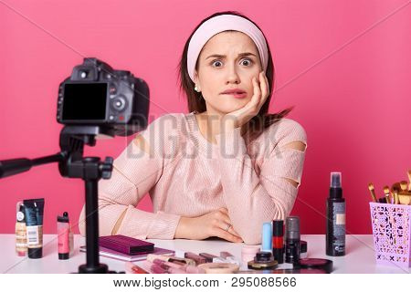 Close Up Portrait Of Attractive Pensive Caucasian Vlogger, Filming Video With Camera On Tripod At Ta