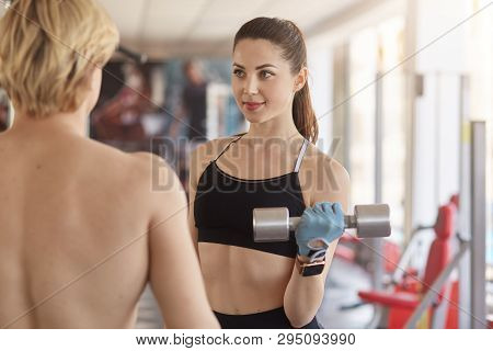 Trainer Men Controls Woman Lifting Dumbbell, Athletic Female Doing Exercise With Instructor In Gym, 