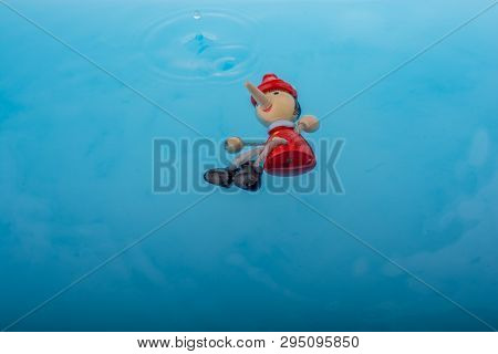 Wodden Puppet Pinocchio On In Blue Water