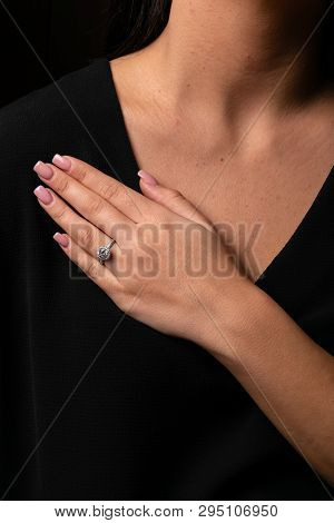 Womens Silver Diamond Ring In The Shape Of A Circle With A Fringe On Finger, On A Black Background.