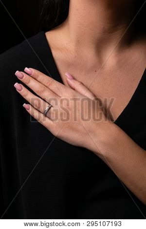 Womens Silver Ring With Diamonds On Finger, On  A Black Background.