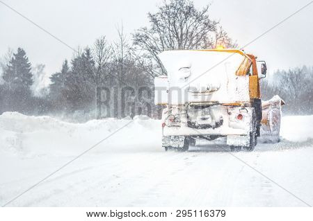 Snow Plow Gritter Cleaning Road During Heavy Winter Snow Storm