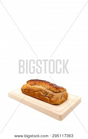A Homemade Plumcake Standing On A Wooden Board With A White Background