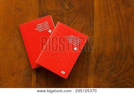 Top View Of Two Swiss Passports On A Wooden Table