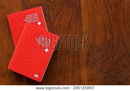 Top View Of Two Swiss Passports On A Wooden Table