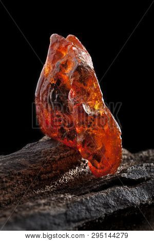 Natural Amber. A Piece Of Yellow And Red Semi Transparent Natural Amber On Piece Of Stoned Wood.