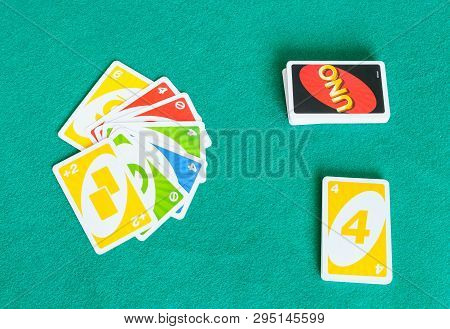 Moscow, Russia - April 3, 2019: Card Decks Of Uno Game On Green Baize Table. Uno Is Shedding-type Ca