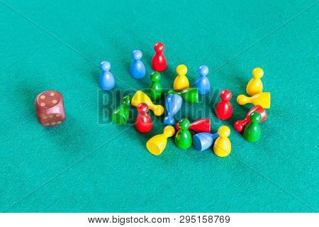 Dice And Many Wooden Board Game Pawns On Green Baize Table