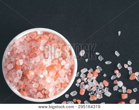 Himalayan Pink Salt In Crystals On Black Stone Background. Copy Space