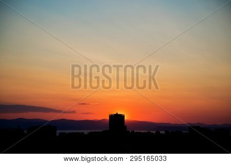 Beautiful Orange Sunset Over A Dark Landscape In The Silhouettes Of The City