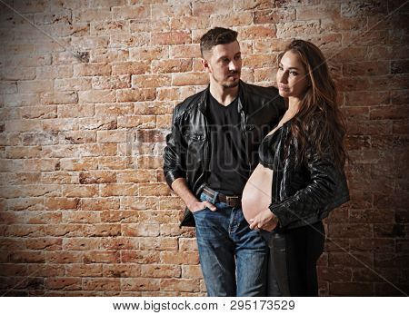 Couple in leather clothes on brick wall background (normal ver)