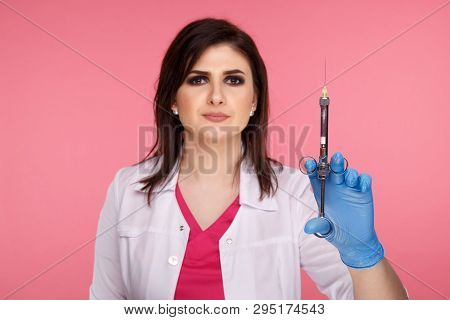 Woman Dentist Posing With Dental Tools Isolated Over The Pink Background.