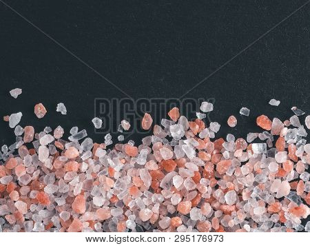 Himalayan Pink Salt In Crystals On Black Stone Background. Copy Space