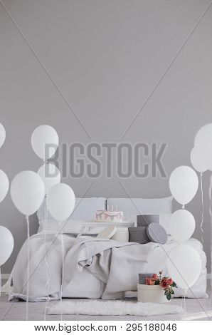 Elegant Bedroom With King Size Bed With Grey Bedding, Birthday Cake And White Balloons, Real Photo W