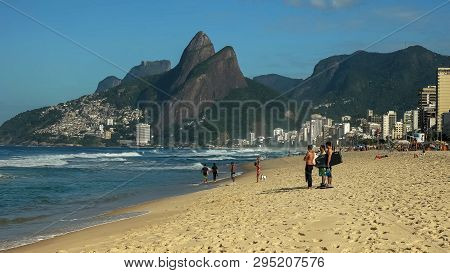 A Group Of Surfers Watch The Waves At Ipanema In Rio