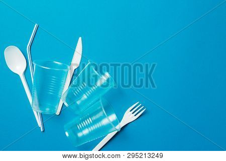 White Single-use Plastic Knife, Spoon, Fork And Plastic Drink Straws On A Blue Background. Say No To