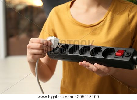 Woman Inserting Power Plug Into Extension Cord Indoors, Space For Text. Electrician's Professional E