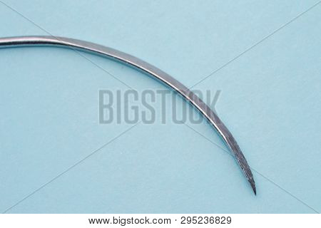 Surgical Traumatic  Needle  On Blue Surface Macro