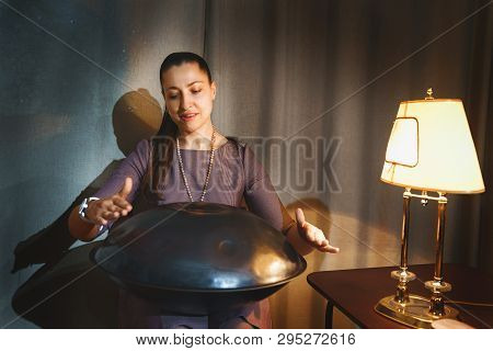 Young Woman Playing On A First Generationan Instrument Called ' Hang ' Or 'hang Drum'