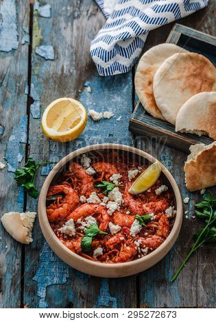 Shrimps Saganaki With Feta Cheese On A Plate On A Table