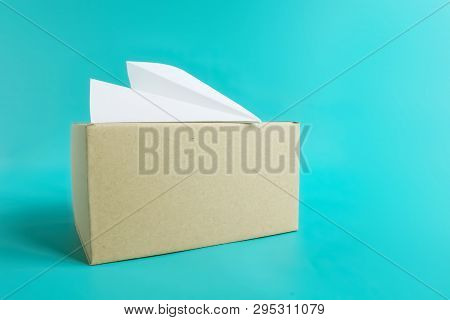 Air Cargo Concept. Paper Plane On Brown Box Isolated On Blue Background. Copy Space For Text