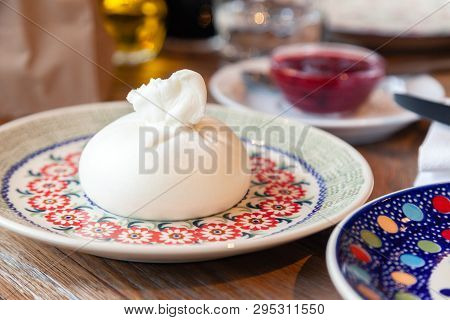 Closeup Fresh Local Italian Soft Round Buratta On Round Color Beautiful Plate With A Pattern Served