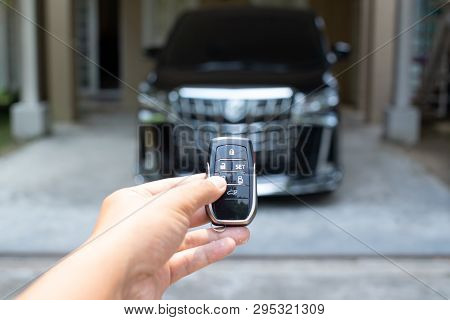 Men's Hand Holding Car Key Ready To Start A New Car With Blurred Black Car Background.hand Hold Key 