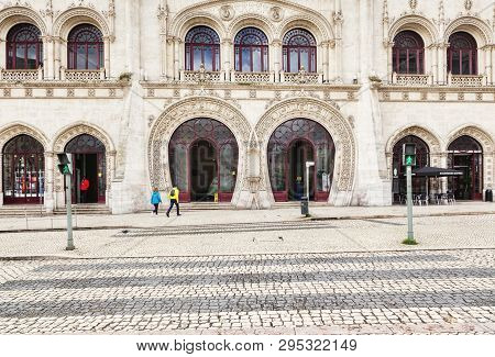3 March 2018: Lisbon, Portugal - The Arched Facade Of Rossio Railway Station, A Couple Making Their 