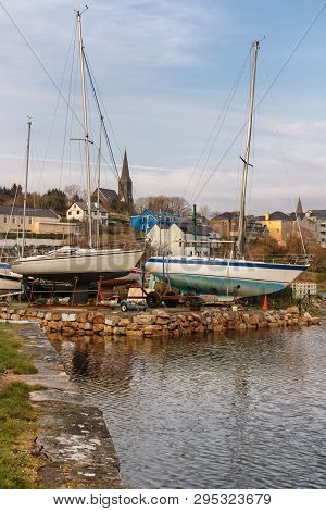 Boats In Clifden Bay Pier With Village In Background