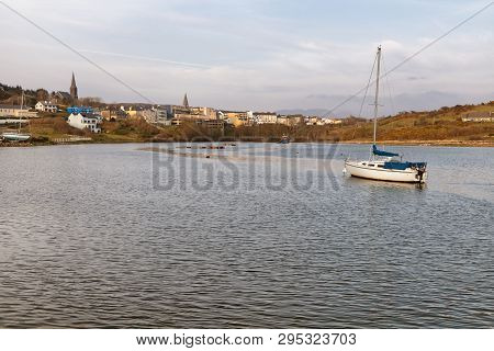 Boat In Clifden Bay With Village In Background