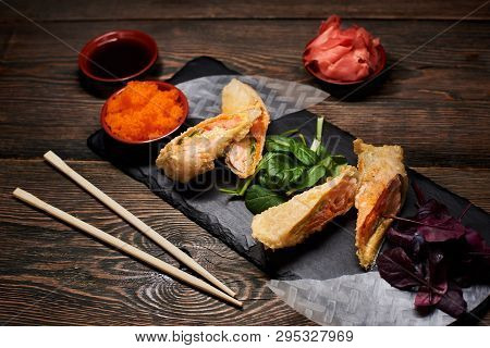 Asian Dish Serving With Green, Red Basil, Rice Paper On Stone Plate. Sauces And Bamboo Chopsticks On