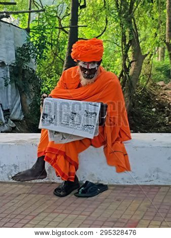 Tiruvanamalai, India - 11 december 2019: Sadhu reading a newspaper in the streets of Tiruvanamalai in India