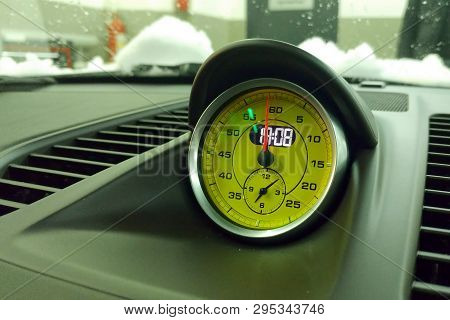 Yellow Exclusive Chronograph In Interior Of Premium Sport Car. On Plastick Podium At The Top Of Dash
