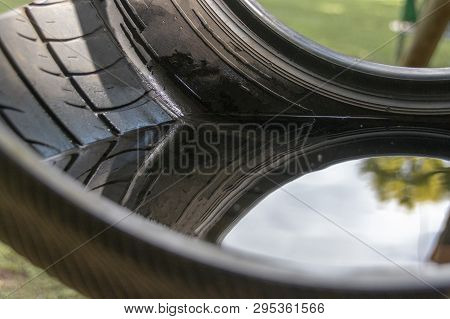 A Close Up View Of The Reflection Of The Trees In Water That Has Been Sitting In A Black Rudder Swin