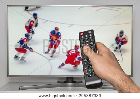 Hockey Match On Tv And Human Hand With Tv Remote Controller