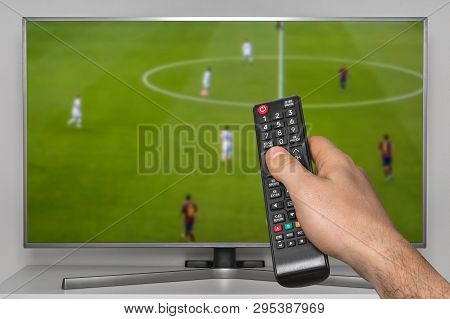 Football Match On Tv And Human Hand With Tv Remote Controller